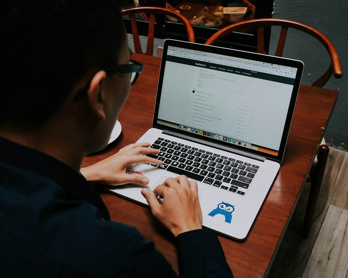 Pria mengisi formulir daring Coretax di laptop di meja kayu