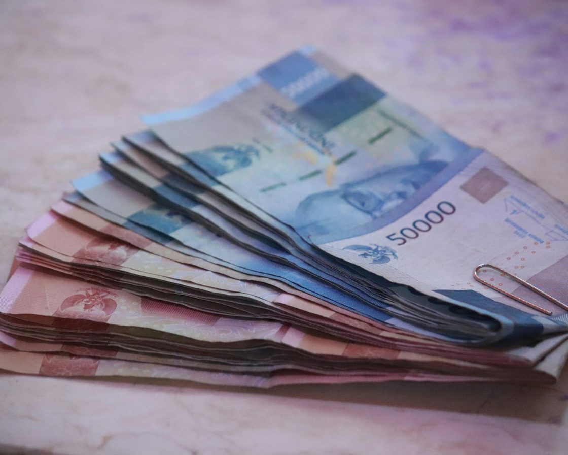 Tumpukan uang kertas rupiah lima puluh ribu dan seratus ribu