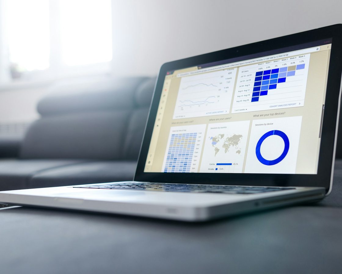 Laptop menampilkan tabel dan grafik data keuangan