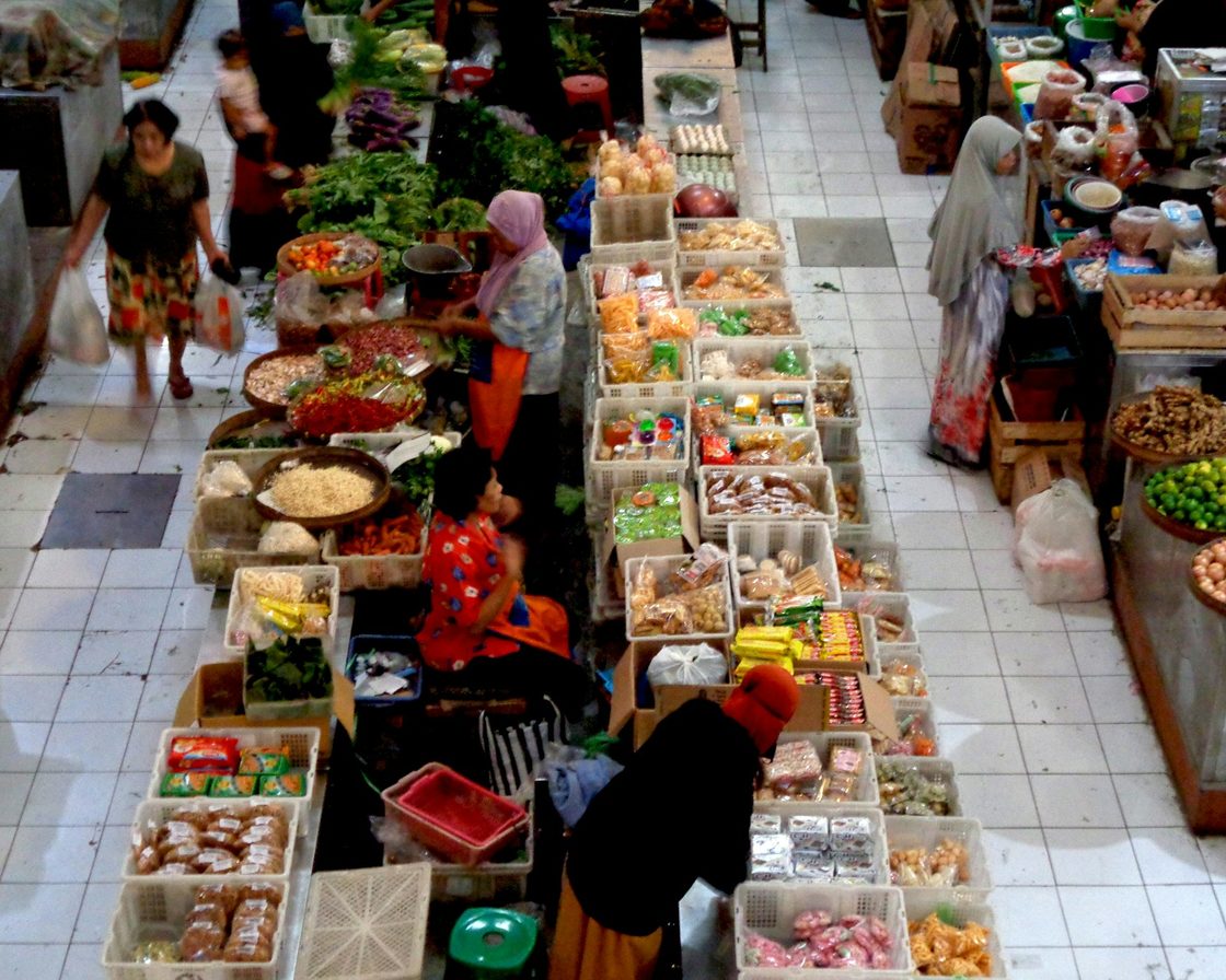 Lorong pasar tradisional dengan pedagang dan pembeli, gambaran pelaku usaha Indonesia