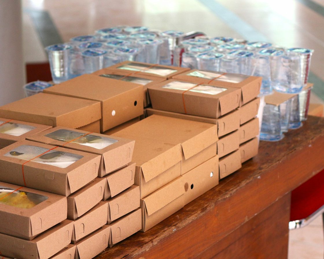 Tumpukan paket kardus siap kirim di meja penjual marketplace