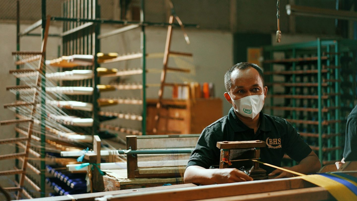 Pekerja bermasker di ruang produksi pabrik tekstil, salah satu sektor yang PPh 21-nya ditanggung pemerintah