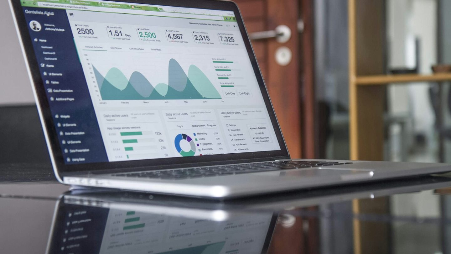 Laptop menampilkan dasbor analitik data di meja kerja